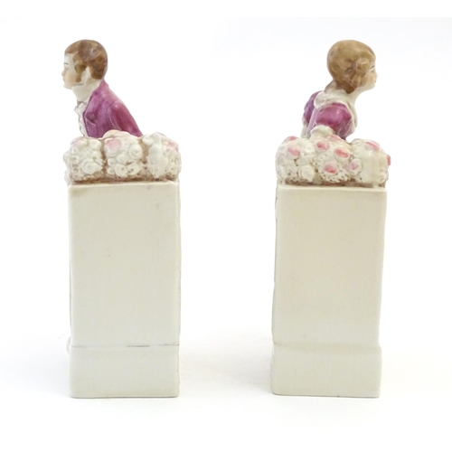 136 - A pair of German porcelain figural bookends depicting a gentleman and a lady with flowers. Marked 18... 