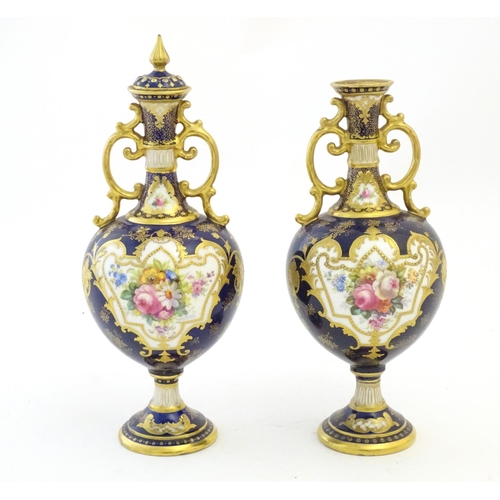 140 - Two Royal Doulton pedestal vases with cobalt blue ground, gilt highlights and hand painted floral an... 