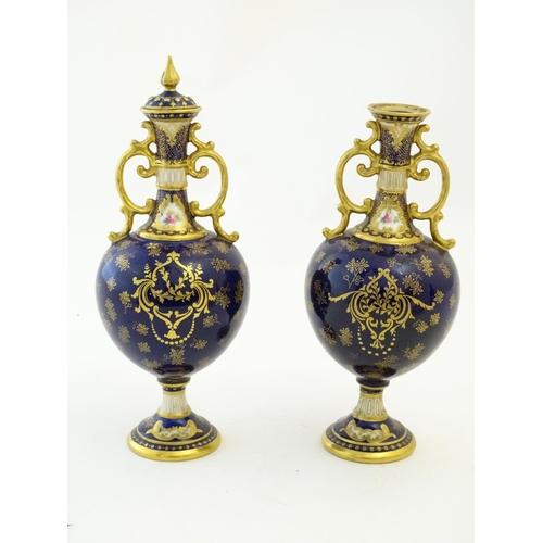 140 - Two Royal Doulton pedestal vases with cobalt blue ground, gilt highlights and hand painted floral an... 