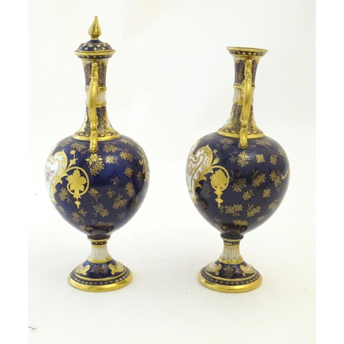 140 - Two Royal Doulton pedestal vases with cobalt blue ground, gilt highlights and hand painted floral an... 