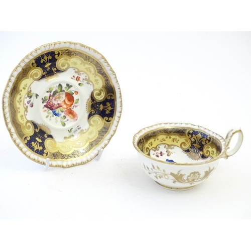 141 - A hand painted tea cup and saucer with a blue ground, gilt highlights and central flower decoration.... 