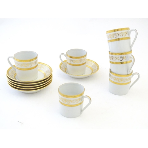 165 - A set of six Limoges coffee cups / cans and saucer with scrolling gilt decoration. Marked under. Cup... 