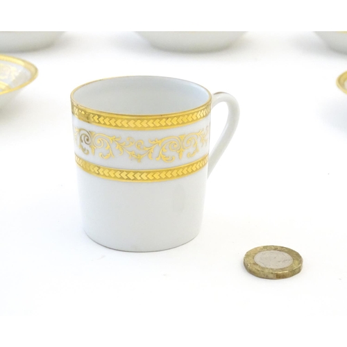 165 - A set of six Limoges coffee cups / cans and saucer with scrolling gilt decoration. Marked under. Cup... 