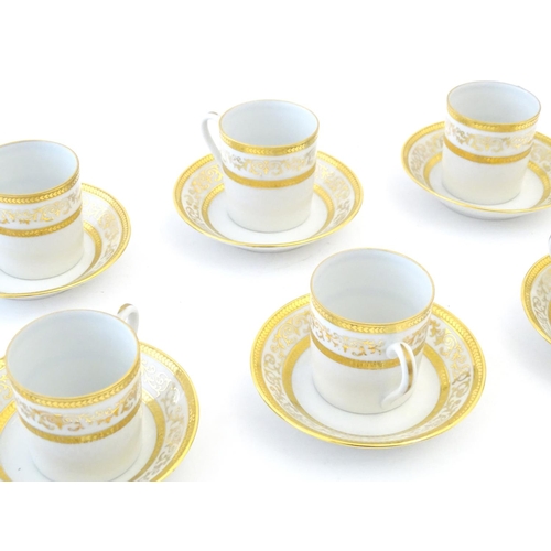 165 - A set of six Limoges coffee cups / cans and saucer with scrolling gilt decoration. Marked under. Cup... 