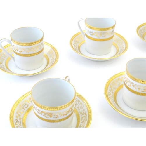 165 - A set of six Limoges coffee cups / cans and saucer with scrolling gilt decoration. Marked under. Cup... 