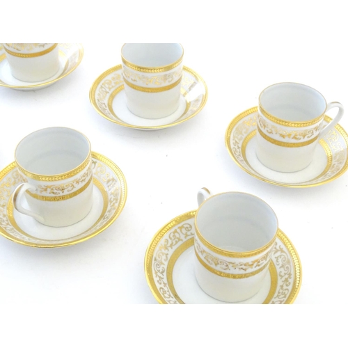 165 - A set of six Limoges coffee cups / cans and saucer with scrolling gilt decoration. Marked under. Cup... 