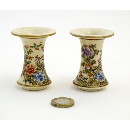 28 - A pair of Japanese miniature Satsuma vases with flared rims and bases, decorated with flowers and fo... 