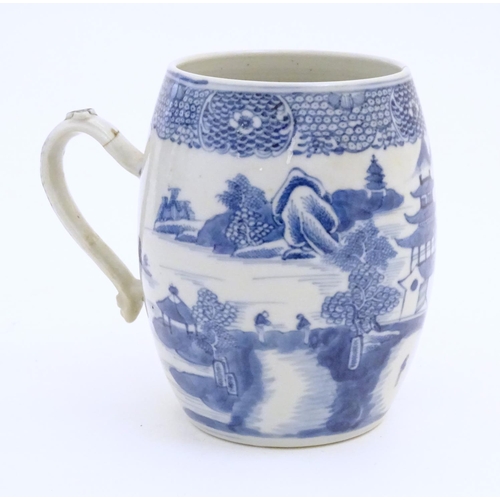 59 - A Chinese blue and white export mug of barrel form decorated with an Oriental landscape with pagodas... 