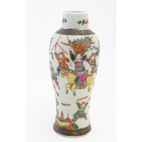 65 - A Japanese crackle glaze vase decorated in famille verte with warriors and horses. Character marks t... 