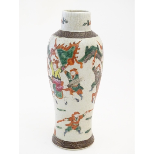 65 - A Japanese crackle glaze vase decorated in famille verte with warriors and horses. Character marks t... 