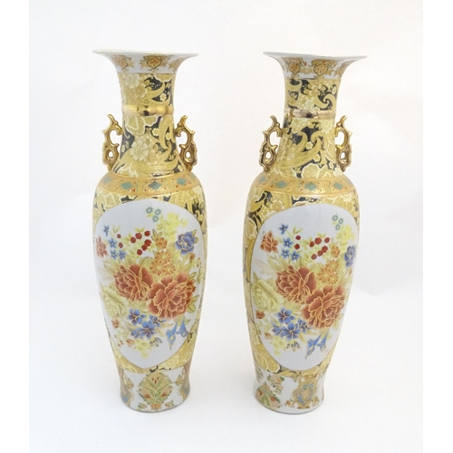 68 - A pair of large Oriental vases with twin handles of stylised form decorated with flowers and foliage... 