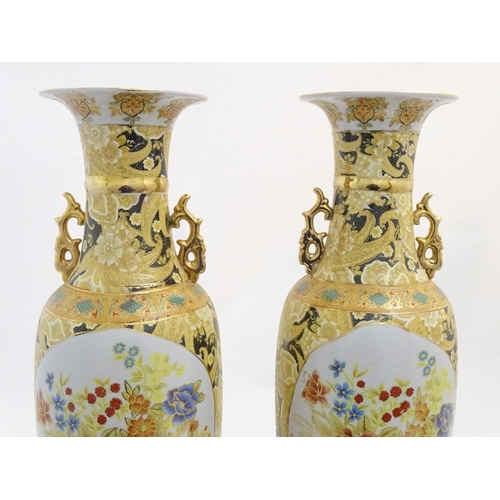 68 - A pair of large Oriental vases with twin handles of stylised form decorated with flowers and foliage... 