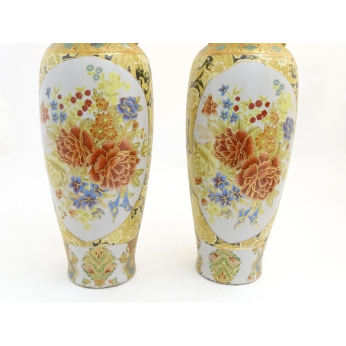 68 - A pair of large Oriental vases with twin handles of stylised form decorated with flowers and foliage... 