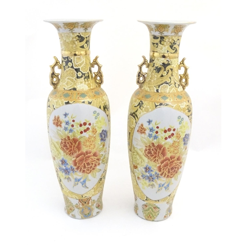 68 - A pair of large Oriental vases with twin handles of stylised form decorated with flowers and foliage... 