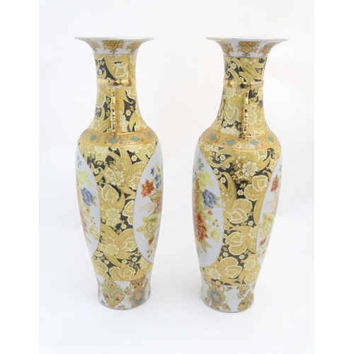 68 - A pair of large Oriental vases with twin handles of stylised form decorated with flowers and foliage... 