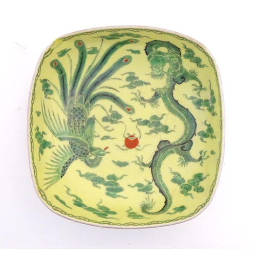 74 - A Chinese famille jaune yellow bowl of oblong form decorated with green dragons among stylised cloud... 