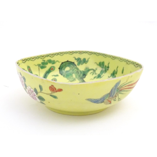 74 - A Chinese famille jaune yellow bowl of oblong form decorated with green dragons among stylised cloud... 