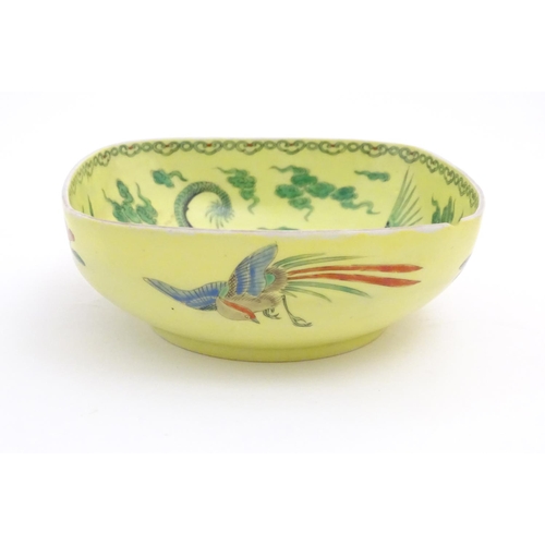 74 - A Chinese famille jaune yellow bowl of oblong form decorated with green dragons among stylised cloud... 