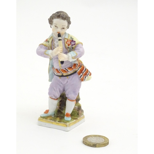 81 - A Continental figure modelled as a boy playing a musical instrument. Marked under. Approx. 4 1/4