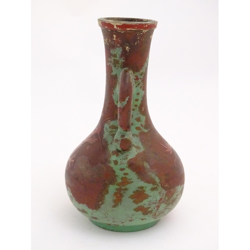 98 - A late 19th / early 20thC bottle vase with shaped twin handles, and dragon decoration. Approx. 9