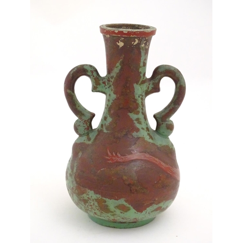 98 - A late 19th / early 20thC bottle vase with shaped twin handles, and dragon decoration. Approx. 9