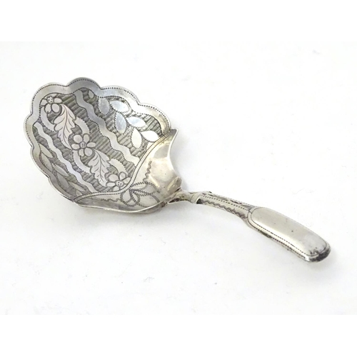 303 - A Geo III silver caddy spoon, the shaped bowl with engraved floral decoration. Hallmarked Birmingham... 