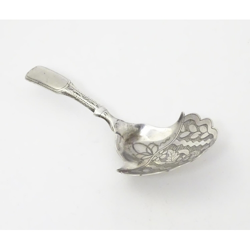 303 - A Geo III silver caddy spoon, the shaped bowl with engraved floral decoration. Hallmarked Birmingham... 