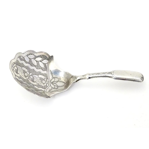 303 - A Geo III silver caddy spoon, the shaped bowl with engraved floral decoration. Hallmarked Birmingham... 