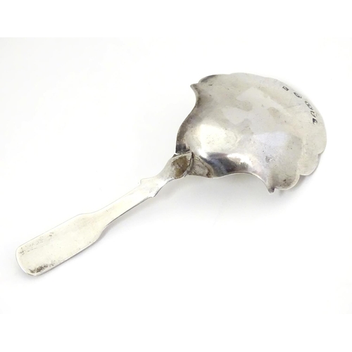 303 - A Geo III silver caddy spoon, the shaped bowl with engraved floral decoration. Hallmarked Birmingham... 