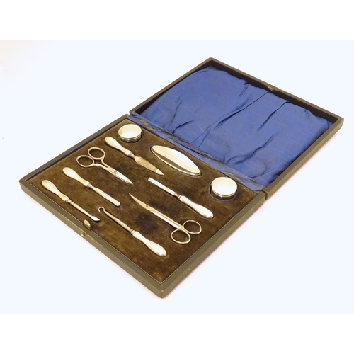 338 - A cased manicure set / necessaire containing silver mounted pots, nail buffer, file, tweezers, etc. ... 