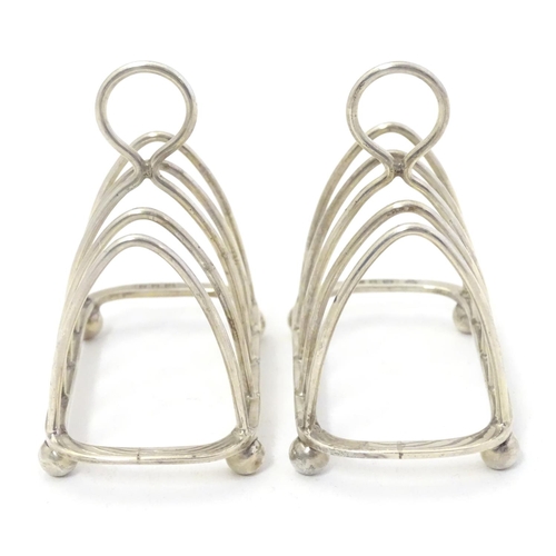 343 - A pair toast racks of 5 -bar arched form. Hallmarked London 1931 maker Harrods Ltd. 3