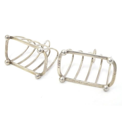 343 - A pair toast racks of 5 -bar arched form. Hallmarked London 1931 maker Harrods Ltd. 3