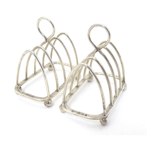 343 - A pair toast racks of 5 -bar arched form. Hallmarked London 1931 maker Harrods Ltd. 3