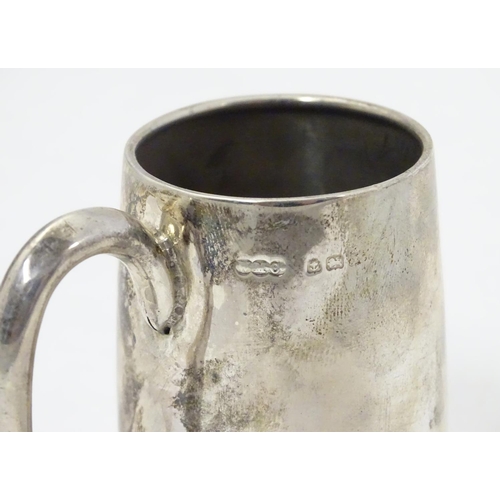 353 - A silver christening mug with loop handle. Hallmarked Birmingham 1918 maker Wilmot Manufacturing Co.... 