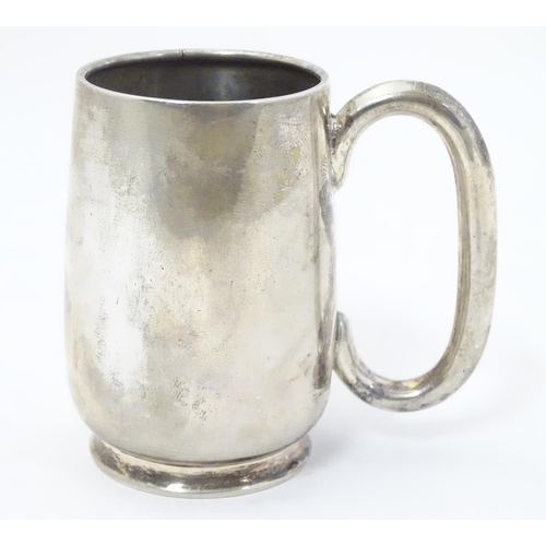 353 - A silver christening mug with loop handle. Hallmarked Birmingham 1918 maker Wilmot Manufacturing Co.... 