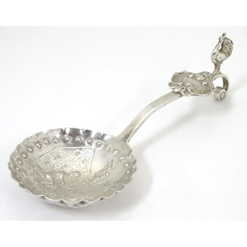 360 - A Continental white metal caddy spoon with landscape scene to bowl and peacock decoration to handle ... 