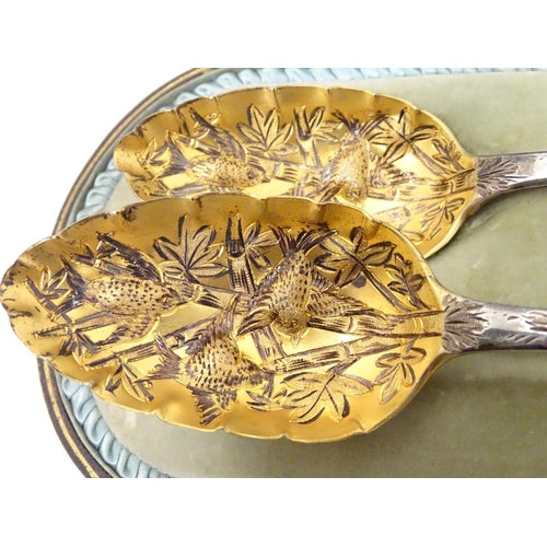 366 - A pair of white metal serving spoons with Aesthetic Movement birds amongst foliage decoration and ha... 