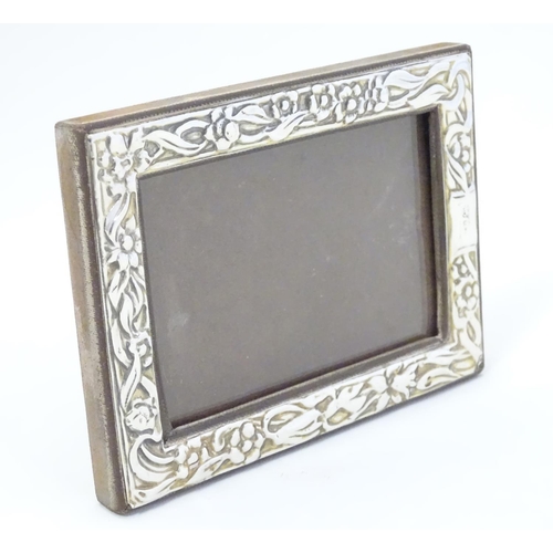 409 - A Silver fronted photograph frame with floral decoration. Import hallmarks for London 1989, importer... 