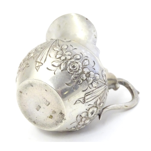 412 - A small Continental silver cream jug with bow and swag decoration. Marked under 800 and with maker’s... 