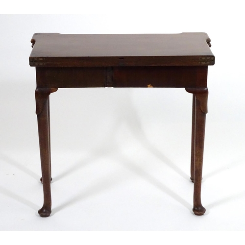 1367 - An early / mid 18thC mahogany card table with a folding top and projecting corners , standing on cab... 