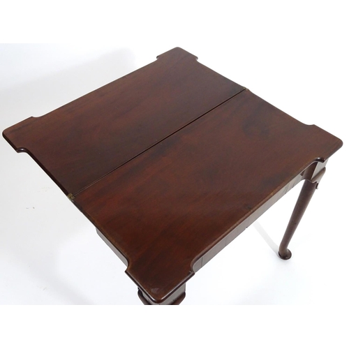 1367 - An early / mid 18thC mahogany card table with a folding top and projecting corners , standing on cab... 