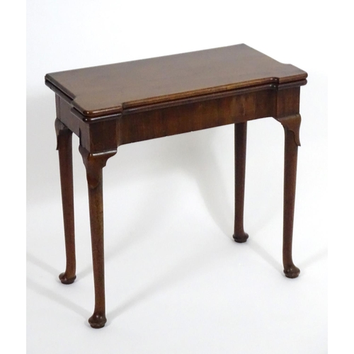 1367 - An early / mid 18thC mahogany card table with a folding top and projecting corners , standing on cab... 