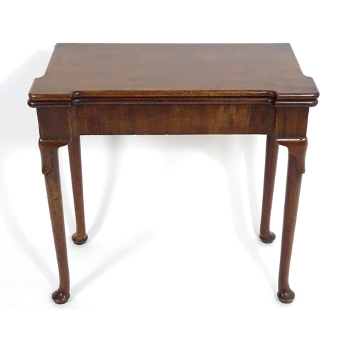 1367 - An early / mid 18thC mahogany card table with a folding top and projecting corners , standing on cab... 