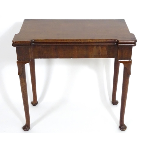 1367 - An early / mid 18thC mahogany card table with a folding top and projecting corners , standing on cab... 