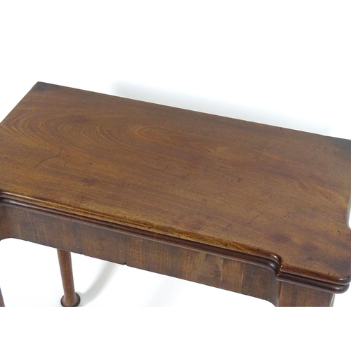 1367 - An early / mid 18thC mahogany card table with a folding top and projecting corners , standing on cab... 