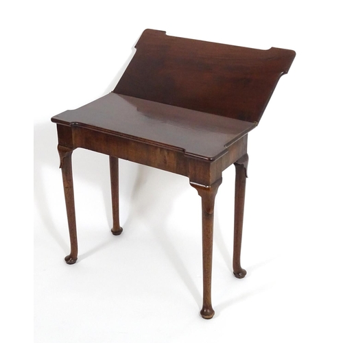 1367 - An early / mid 18thC mahogany card table with a folding top and projecting corners , standing on cab... 