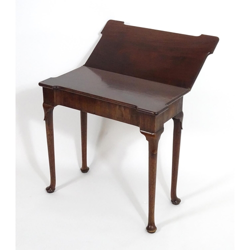 1367 - An early / mid 18thC mahogany card table with a folding top and projecting corners , standing on cab... 