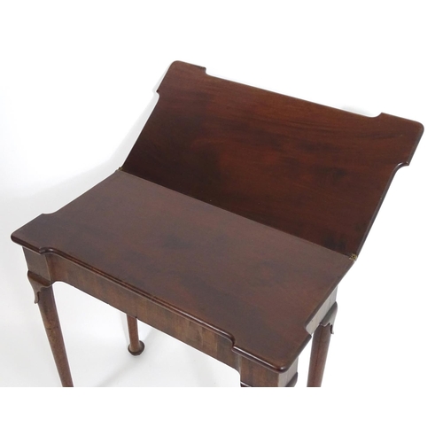 1367 - An early / mid 18thC mahogany card table with a folding top and projecting corners , standing on cab... 