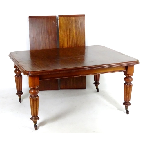 1368 - A late 19thC mahogany dining table, having a moulded edge above four turned tapering legs with reede... 