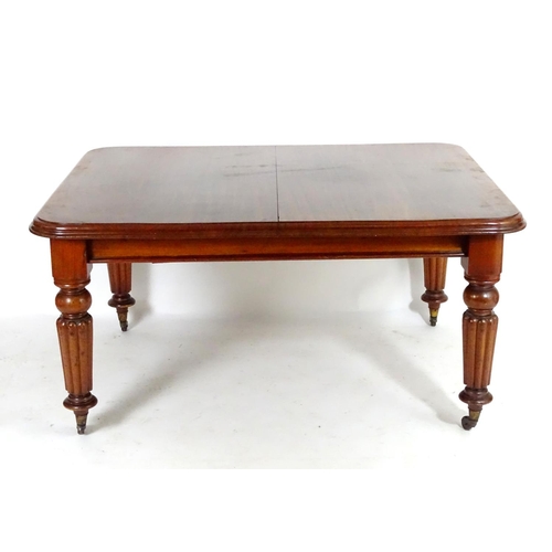 1368 - A late 19thC mahogany dining table, having a moulded edge above four turned tapering legs with reede... 